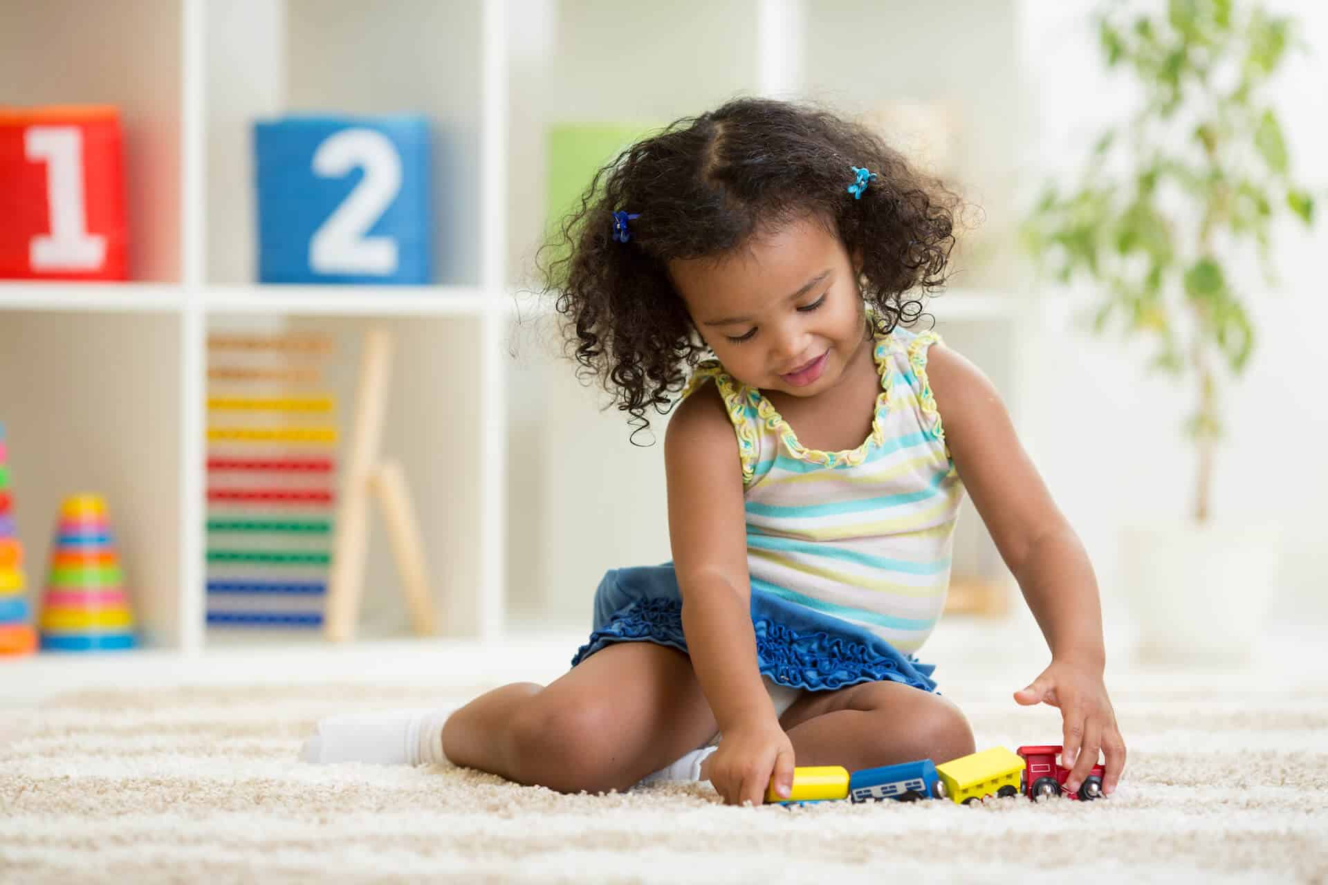 girl playing colorful cars